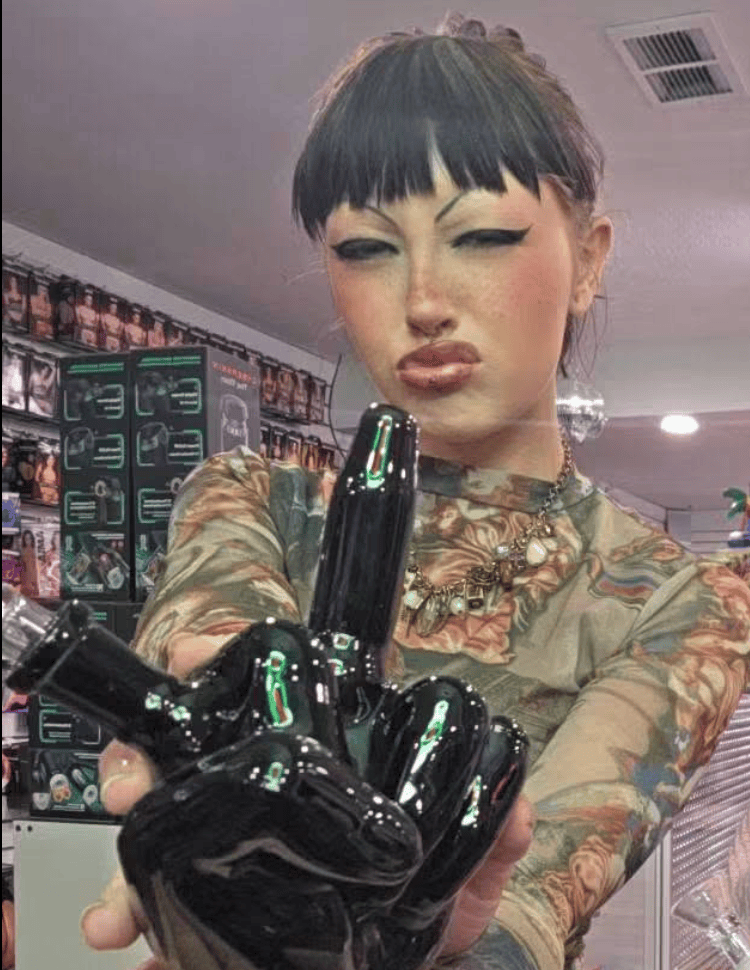 Rem employee at Paradise for Adults in Centralia, WA holding a ceramic middle finger bong.