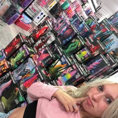 Paradise For Adults employee Liv showcasing the vibrant Creature Cocks novelty collection display at the adult store in Centralia, WA.